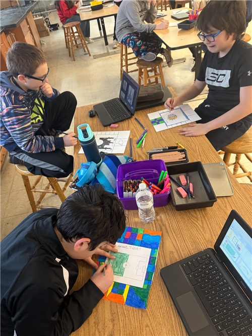 Three male students work at a table with art supplies, creating illustrations in the style of Faith Ringgold.